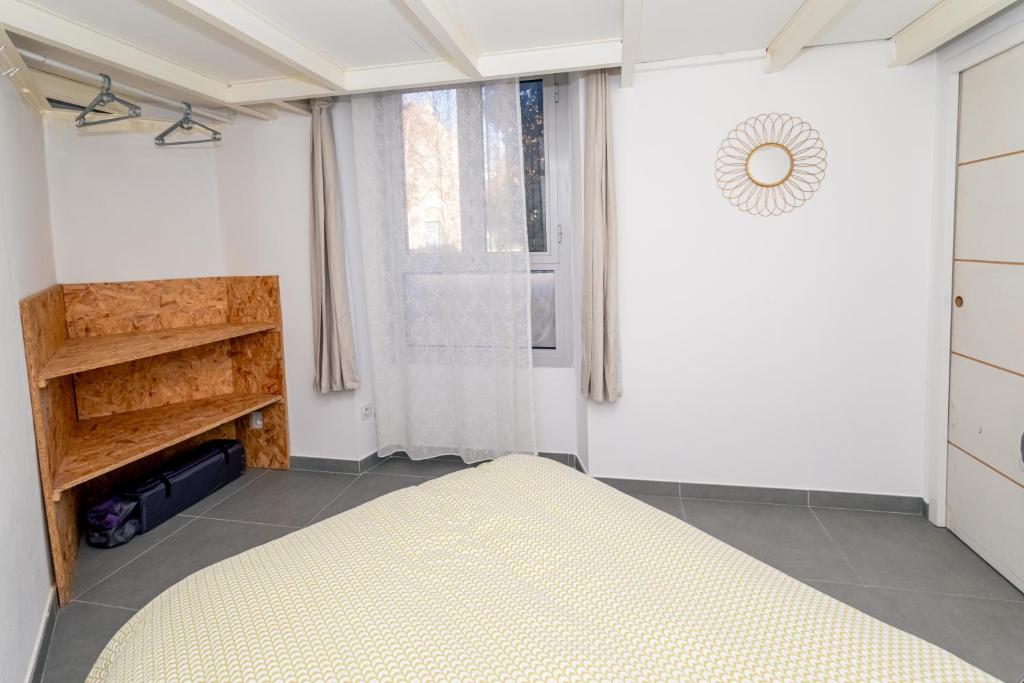 1 dormitorio con cama y ventana en 44m2 Family Holiday&Business Appartment Access et Parking Facile LitBébé Clim Wifi 1BedRoom 1SofaBed 1BabyBed Easy Access AirConditioning FreeParking FreeWifi, en Béziers