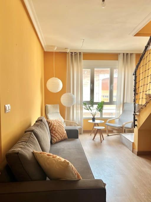 een woonkamer met een bank en een stoel bij BaruHaus Terraza Duplex Valencia de don Juan in Valencia de Don Juan