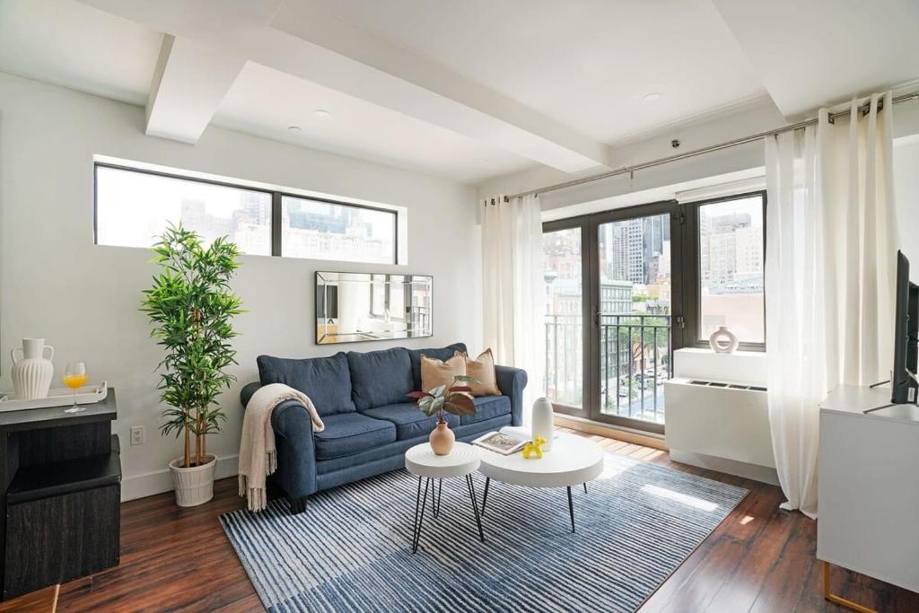 a living room with a blue couch and some windows at 809-6A NEW 2BR Private Roof & City View in New York