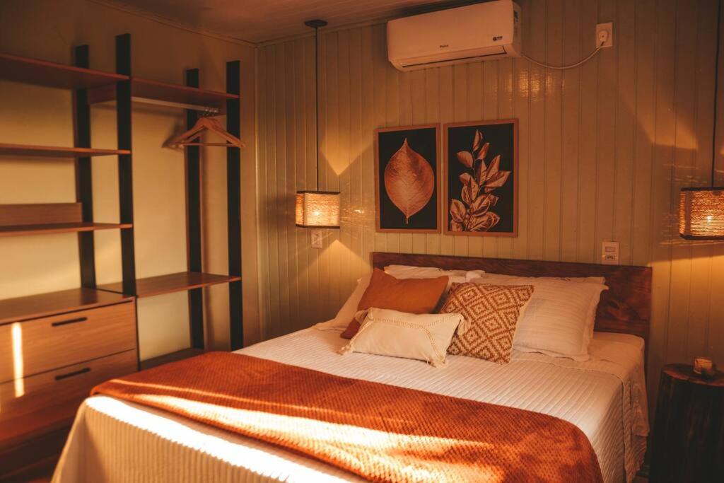 Un dormitorio con una cama con almohadas. en Refúgio do Sol Park Pousada - Cabana - Hospedagem, 