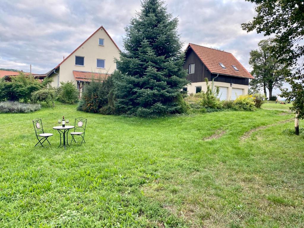 un tavolo e sedie in un cortile con una casa di Familienbauernhof Lehmann a Weißenberg