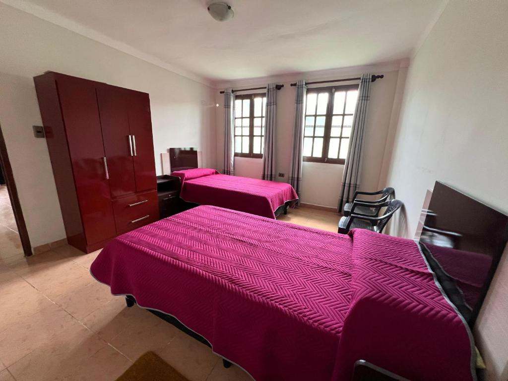 2 letti in una camera con lenzuola rosa di Casa Amigable y Confortable a Yacuiba