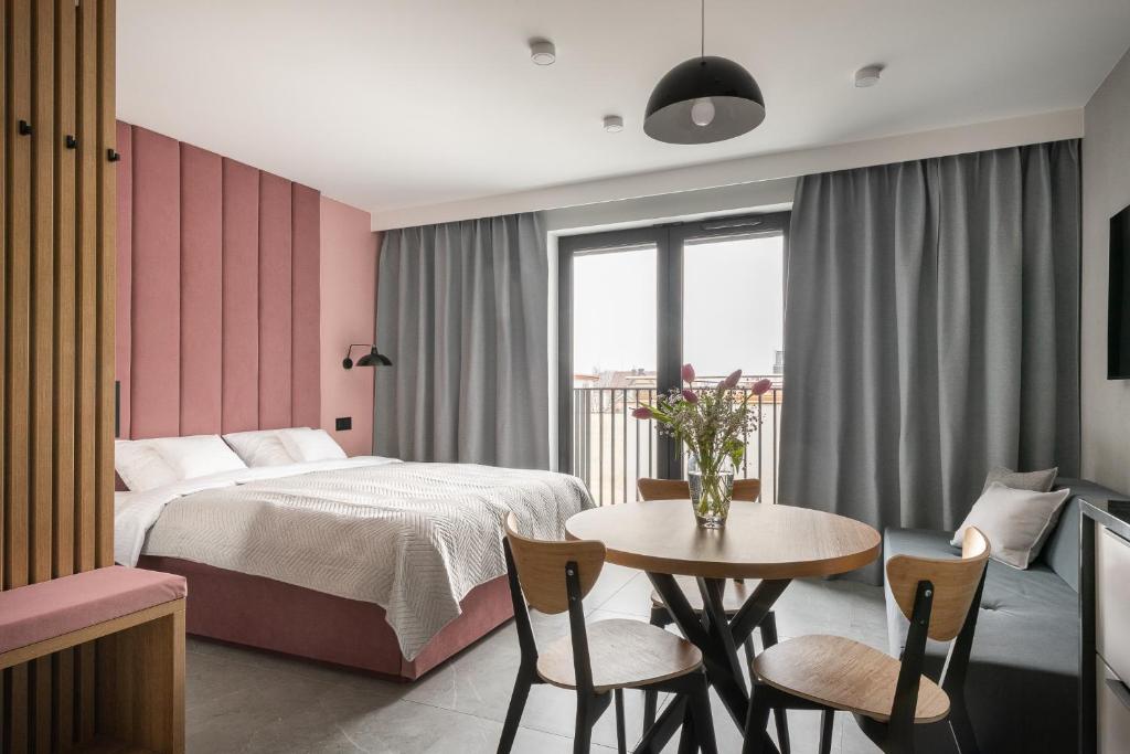 1 dormitorio con 1 cama, mesa y sillas en AVAPARTS Apartament ROSE en Jastarnia