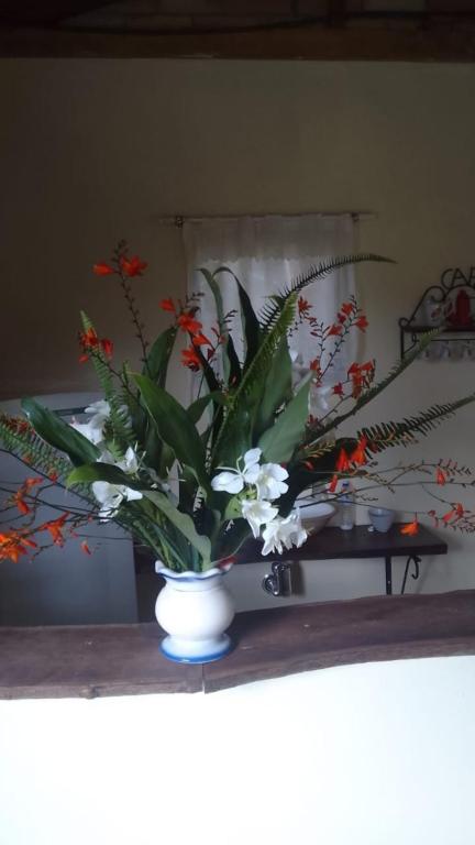 un jarrón lleno de flores en una mesa en Chalé Ângico, en Aiuruoca