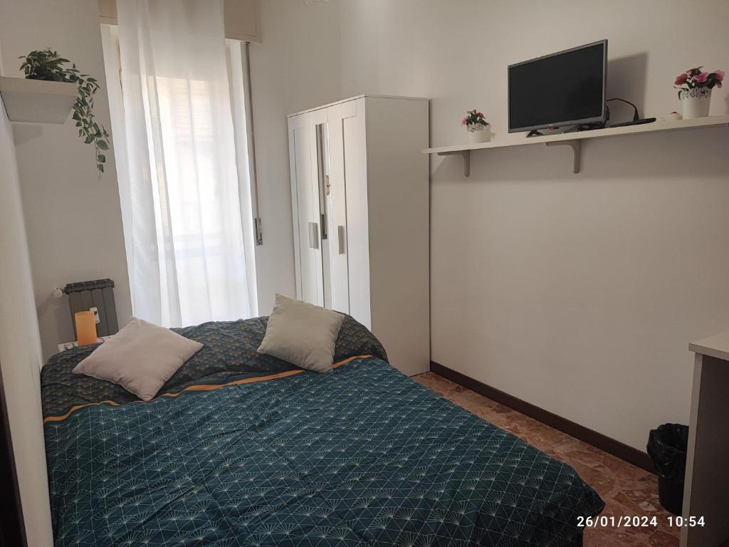 a bedroom with a bed with pillows and a tv at CASA DI LORY in Milan