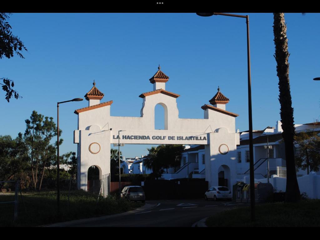 uma igreja branca com um sinal em frente em Luxury Hacienda Golf Islantilla em Islantilla