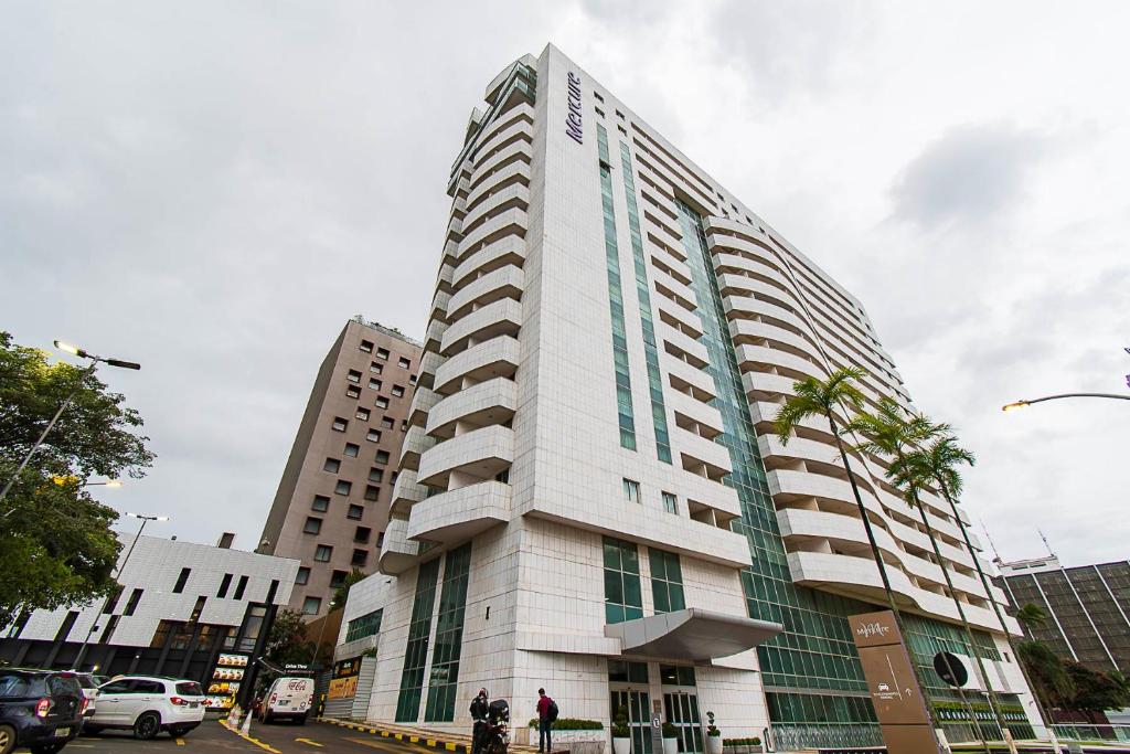 a tall white building on a city street at GS Properties - Hotel Líder in Brasilia