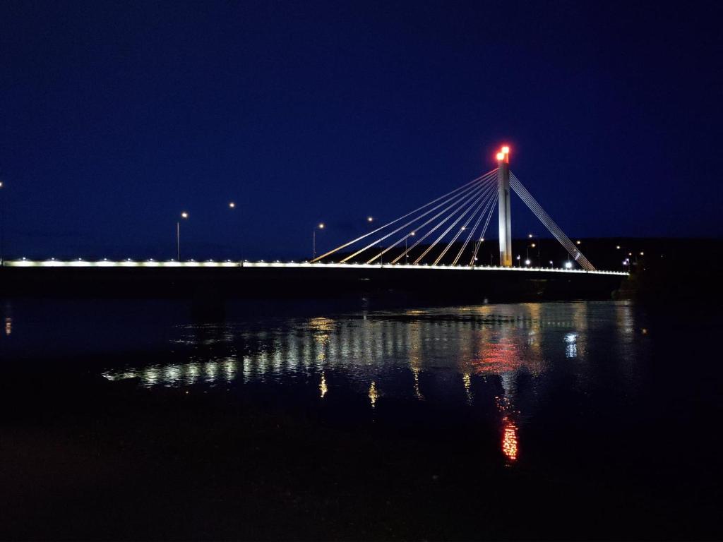 a bridge over a body of water at night at Coloria - kotisi Rovaniemellä, luonnollisesti in Rovaniemi
