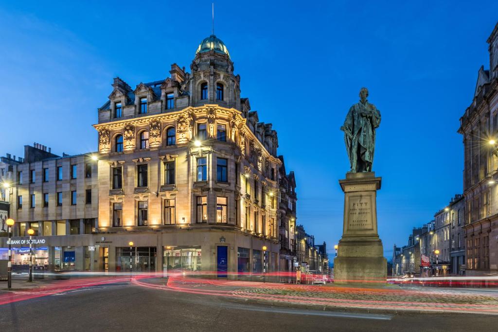 a statue in the middle of a street in front of a building at RÌGH Residences - George Street in Edinburgh