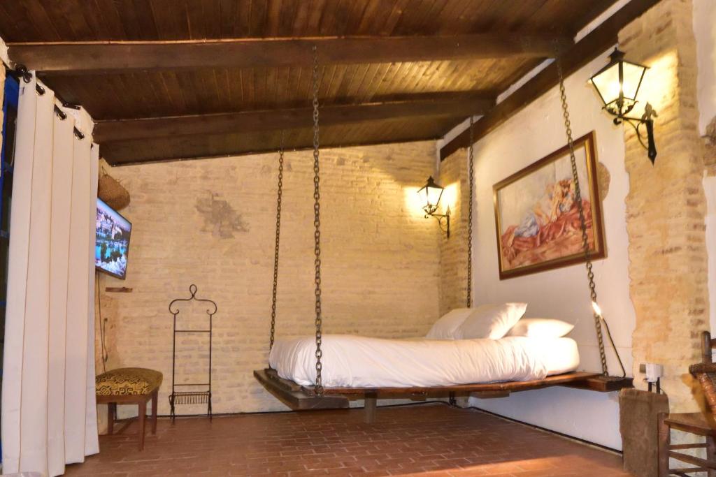 a bedroom with a swinging bed in a room at Casa Tenorio Barrio de Santa Cruz in Seville