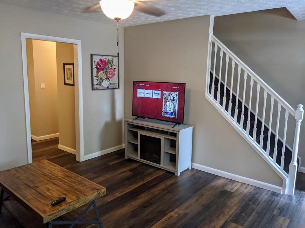 Una sala de estar con un televisor de pantalla plana en un centro de entretenimiento. en Carter #5 Two bedroom unit near Xavier Downtown, en Cincinnati