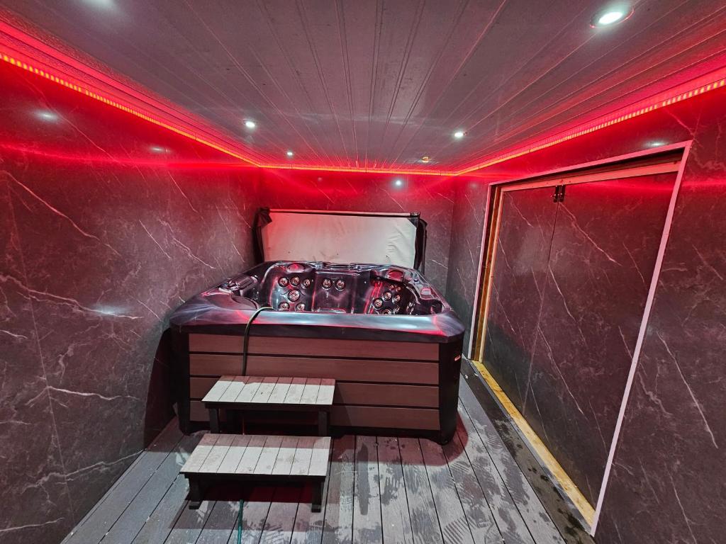 a room with a bed with red lights on it at Hot tub hideaway in Manchester