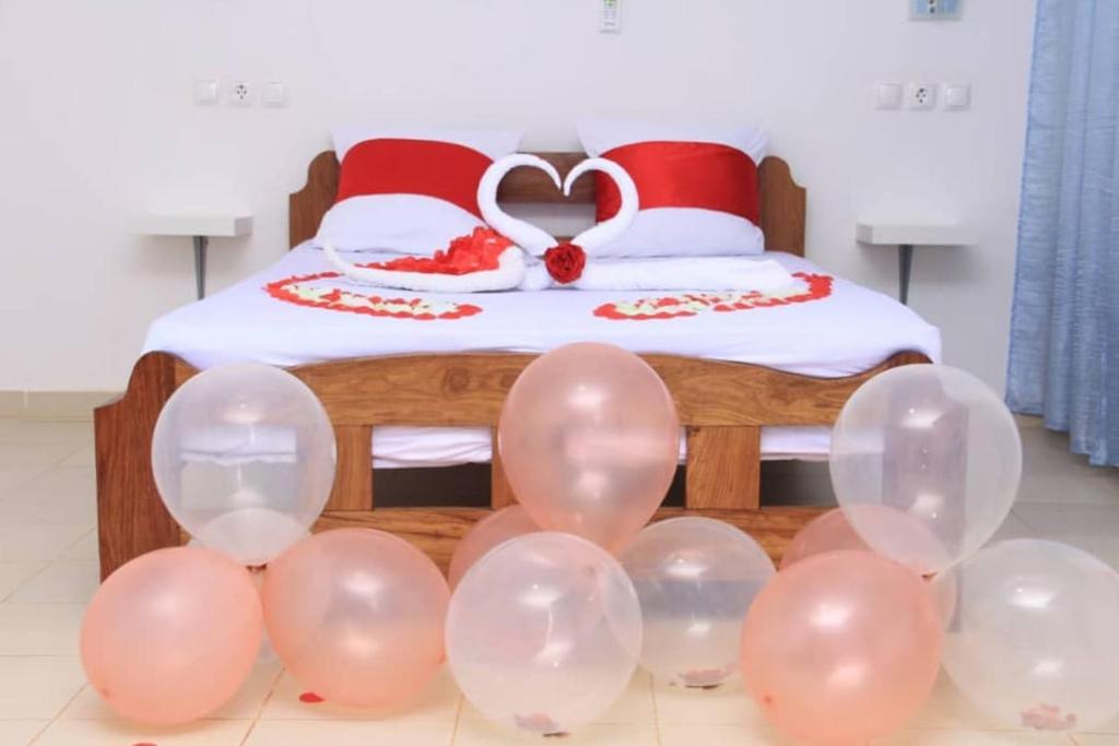 un mucchio di palloncini rosa davanti a un letto di CASA CAMBA MAR a Bissau