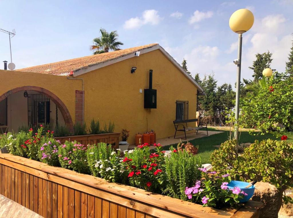 une maison avec un jardin fleuri devant elle dans l'établissement CASA MARIA, à Murcie