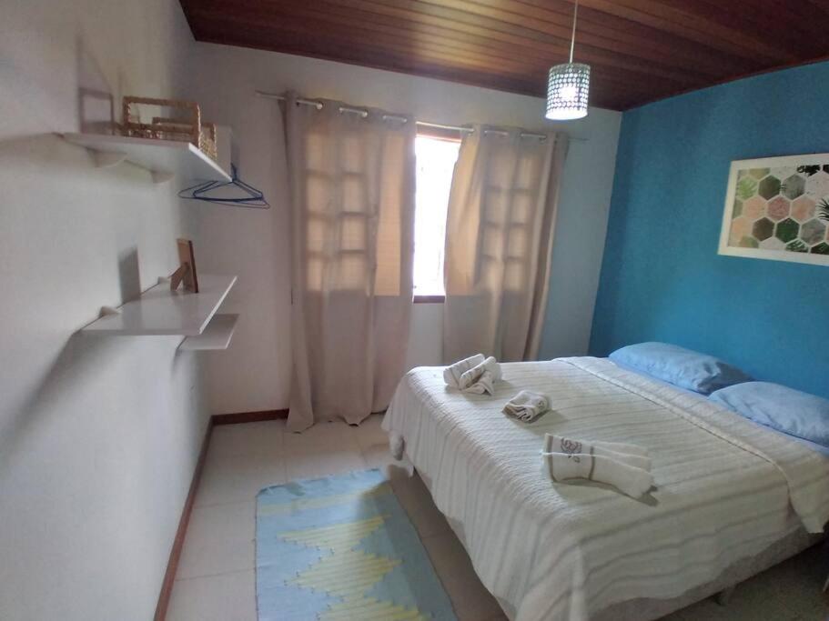 een slaapkamer met een bed met blauwe muren en een raam bij Curta o verde da montanha in Teresópolis
