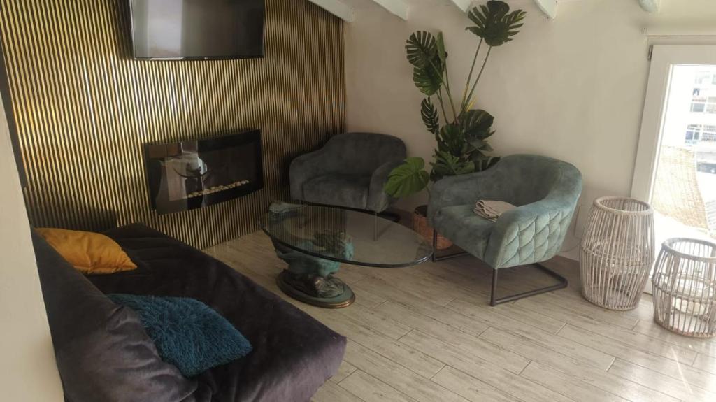 uma sala de estar com duas cadeiras e um sofá e uma televisão em Casa Roberto Altea em Altea