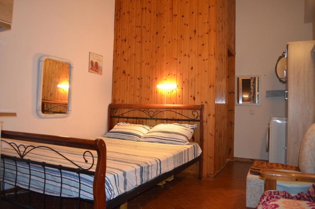 a bedroom with a bed with a wooden wall at Nick Apartment in Zakynthos