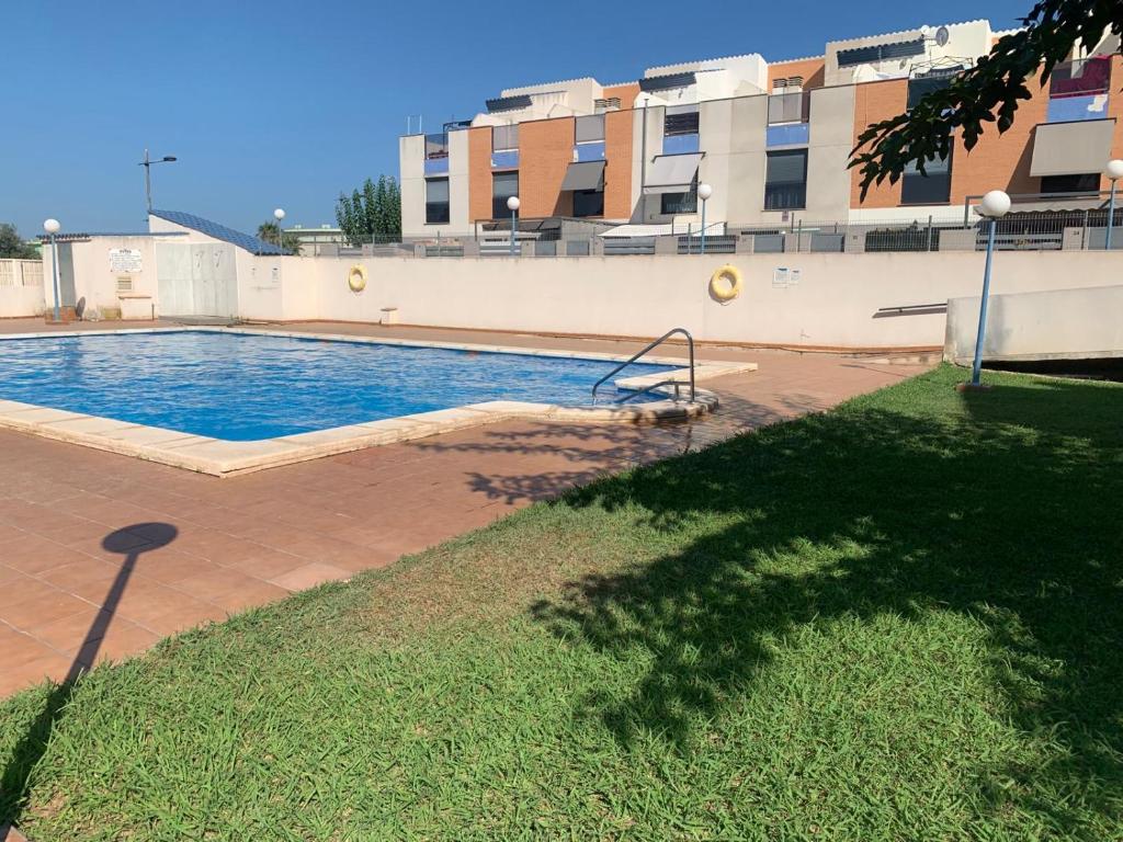 une grande piscine en face d'un bâtiment dans l'établissement Belle maison de vacances, à Grao de Castellón