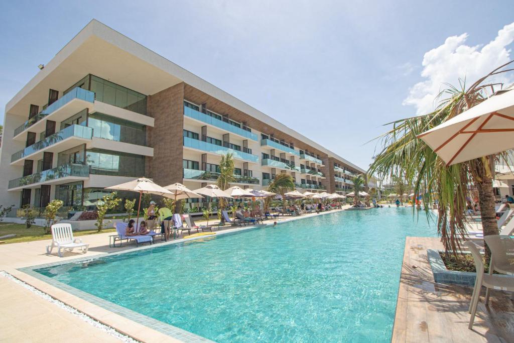 a swimming pool in front of a hotel at Maceio Mar Resort All Inclusive in Maceió