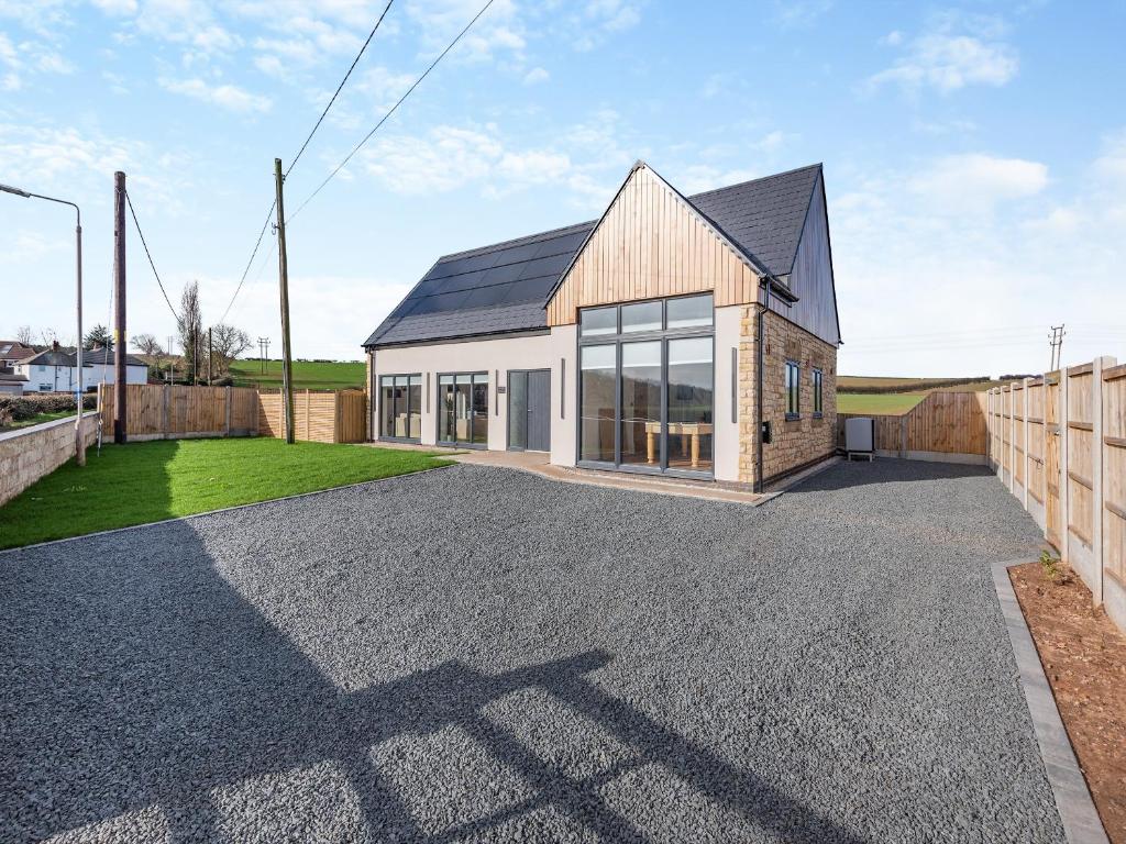 a house with a driveway and a fence at Cedar Lodge in Mansfield Woodhouse