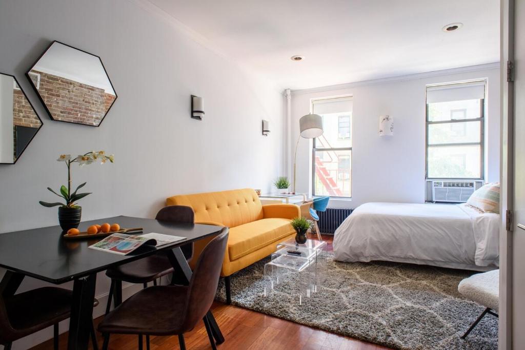 a living room with a yellow couch and a bed at 24-10 Studio Prime Gramercy WD in Unit in New York