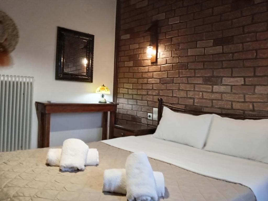 1 dormitorio con 1 cama con toallas en Elaias Gea -Kalampaka, en Kalambaka