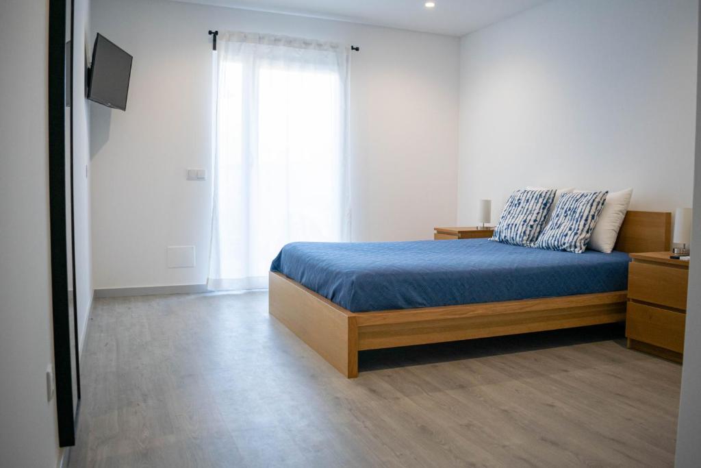 a bedroom with a bed and a large window at Alojamento Moinho d`Óbidos in Óbidos