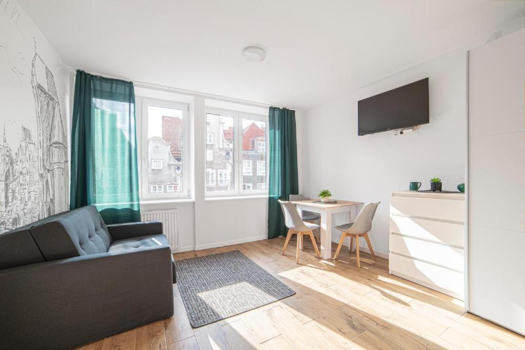 a living room with a couch and a table at Grobla -Old Town by Grand Apartments in Gdańsk
