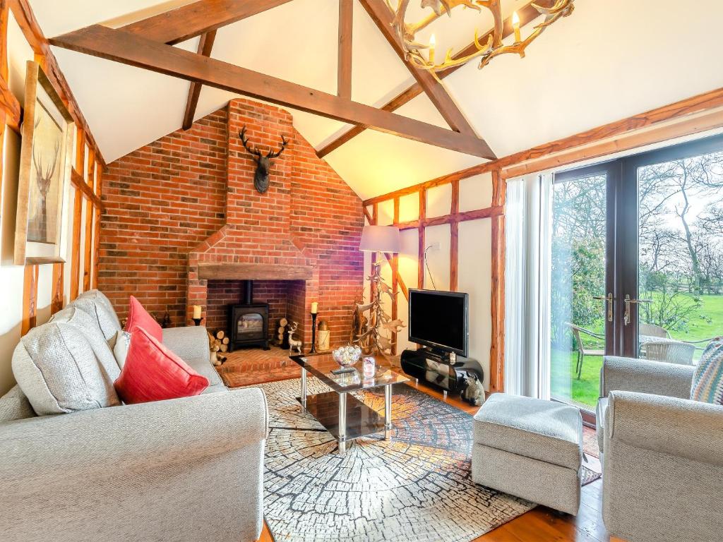a living room with a large brick fireplace at Bluebell Lodge - Uk46412 in Burgh le Marsh