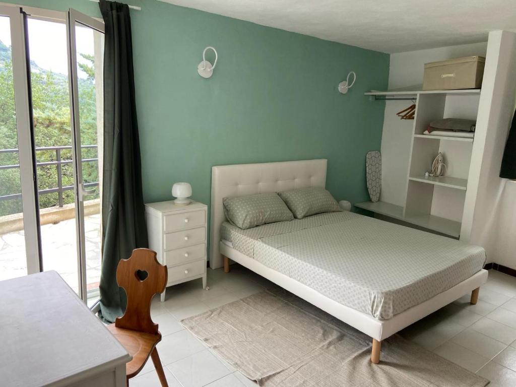 a bedroom with a bed with a green wall at La casa degli Ulivi in Camporosso