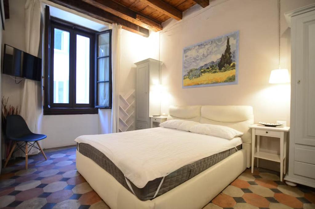 een slaapkamer met een wit bed en een raam bij F1 - Santa Croce one bedroom apartment for couples in Florence