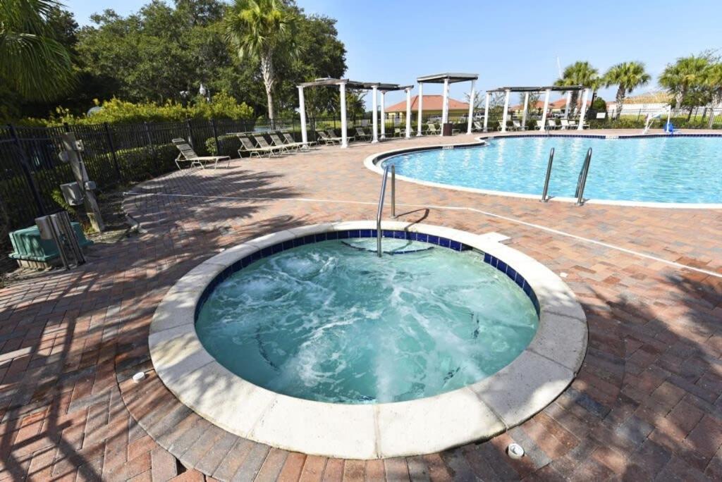 a hot tub in a patio next to a swimming pool at Lovely Lakeside 4-Bed Pool Home at Villa Sol-3125 in Kissimmee