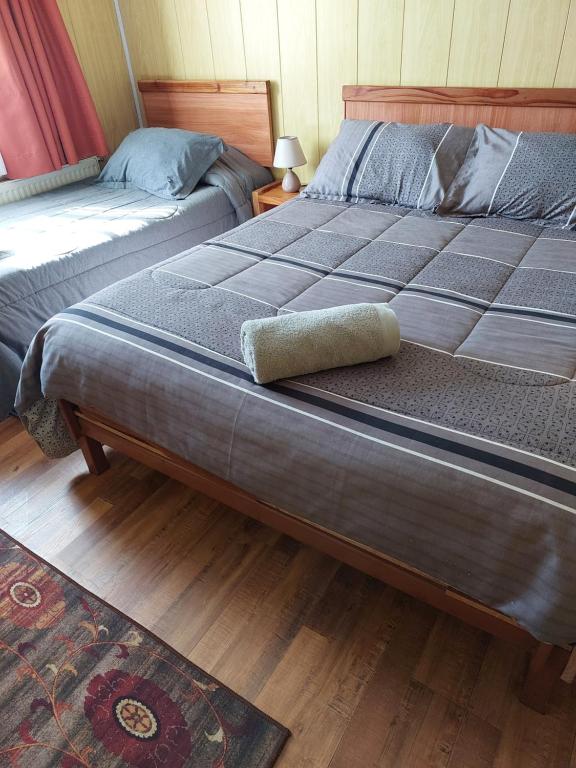 two beds sitting next to each other in a bedroom at Hostal Prat 2 in Valdivia