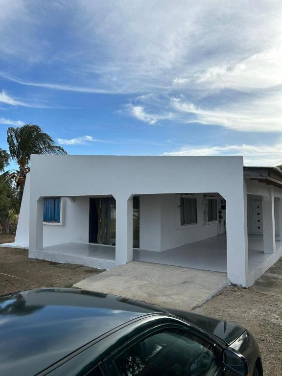 ein weißes Haus mit einem davor geparkt in der Unterkunft Casa Fransina in Blue Bay