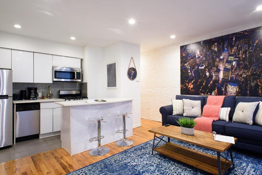 ein Wohnzimmer mit einem Sofa und einer Küche in der Unterkunft 26-4B Newly Furnished 1BR W D Courtyard in New York