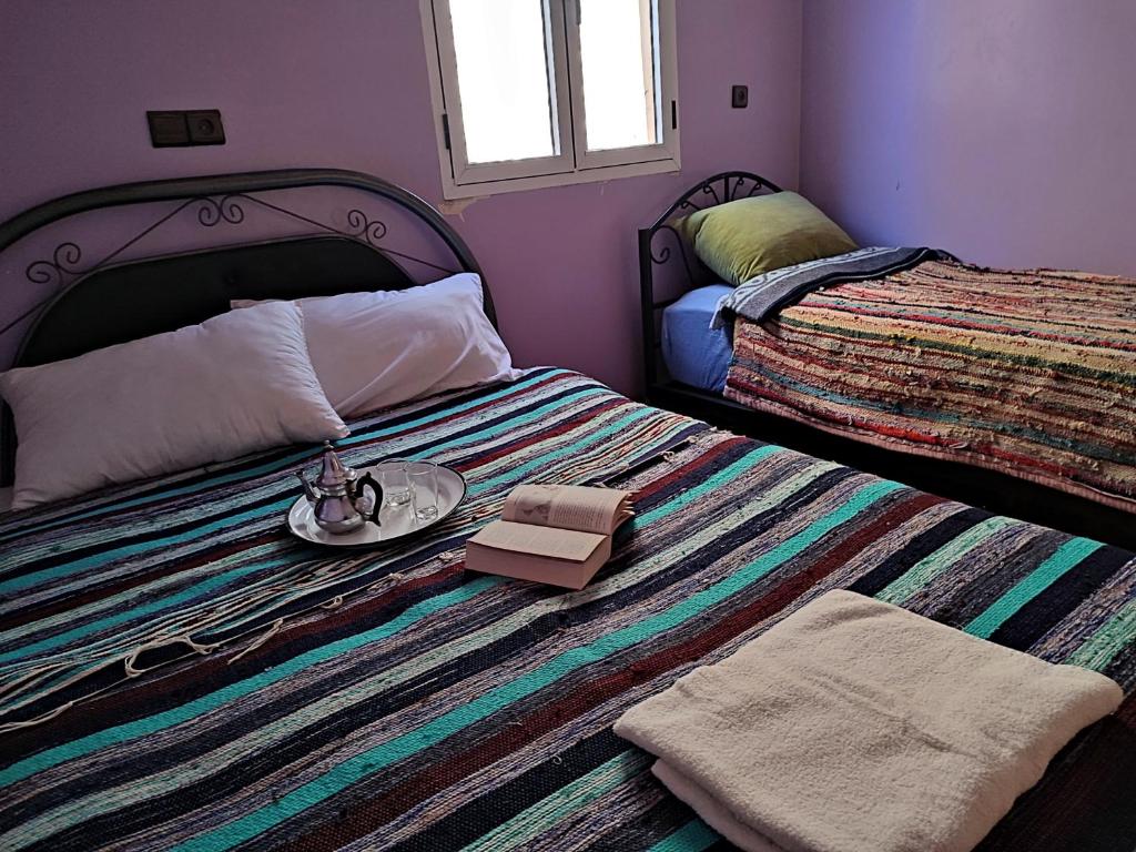 a bedroom with a bed with a plate on it at Tifinagh Guest House in Merzouga