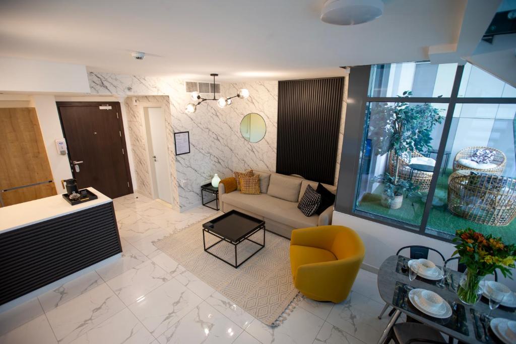 - un salon avec un canapé et un fauteuil jaune dans l'établissement Duplex Delight in Al Raha, à Abu Dhabi