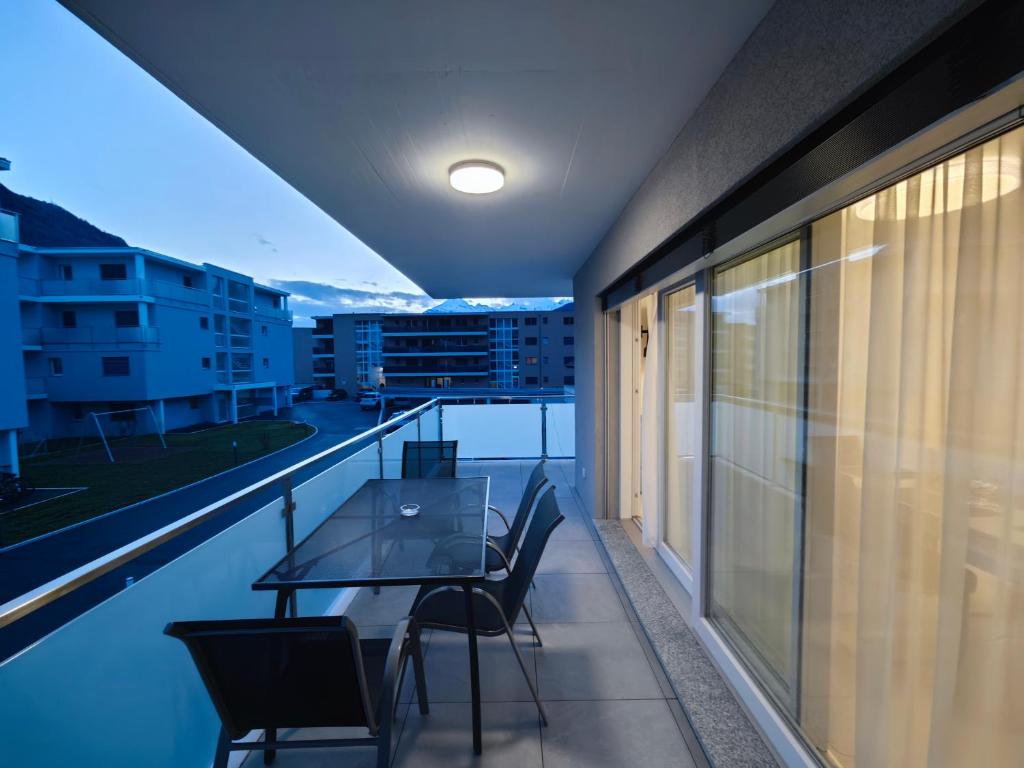 a balcony with a table and chairs on a roof at A côté de l'îles Sion in Sion