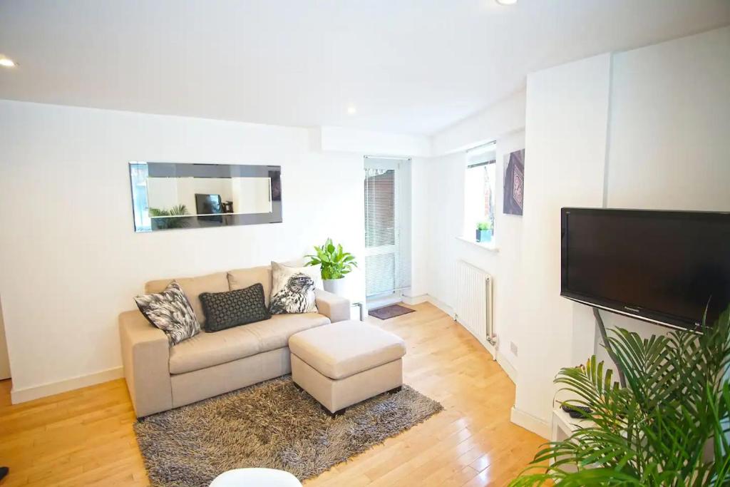 a living room with a couch and a flat screen tv at Superior Canary Wharf O2 Arena 2Bed Apartment in London