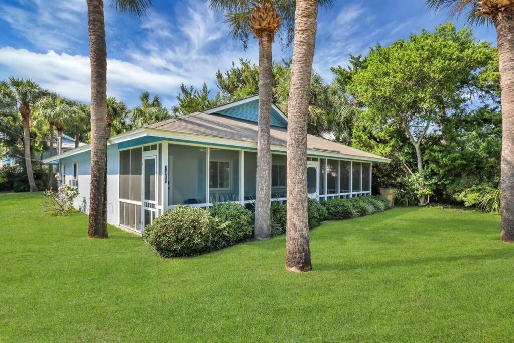 una casa con palmeras en un patio en Gem by the Beach Unit A Walk to Beach, Shops, Bars, en Tybee Island