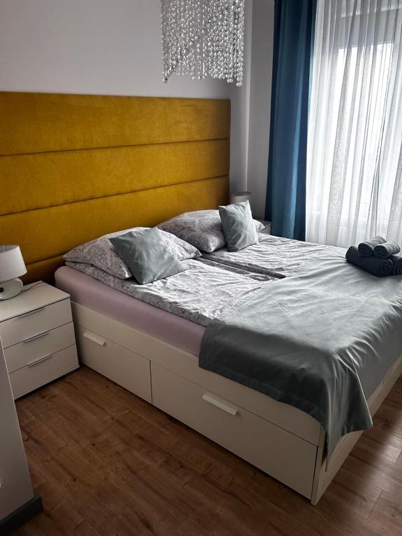 Apartament Walczaka 46 MIEJSCE PARKINGOWE في جورزو فيلكوبولسكي: سرير مع اللوح الأمامي الأصفر في غرفة النوم