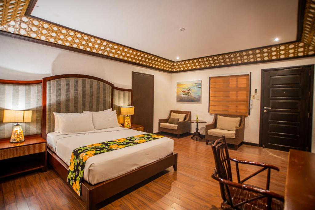 a bedroom with a bed and a desk and a chair at Club Agutaya in San Vicente