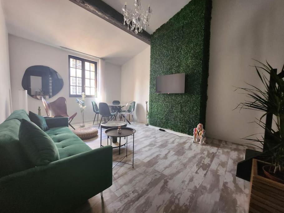 een woonkamer met een groene bank en een tafel bij L'Elégant in Montauban
