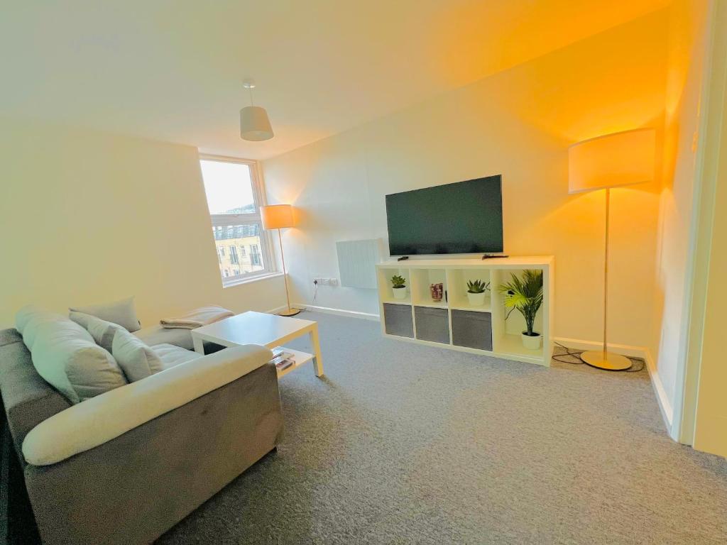 uma sala de estar com um sofá e uma televisão de ecrã plano em Entire Flat in Canary Wharf em Londres