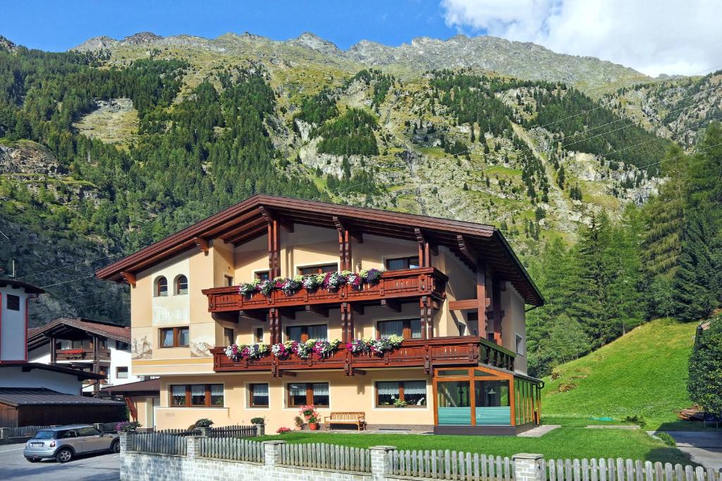 a building with a balcony with flowers on it at Apart Alpina Huben in Längenfeld