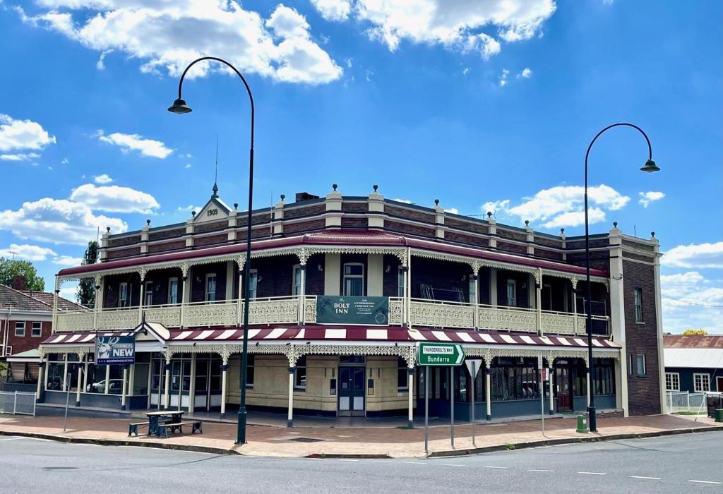 a building on the corner of a street with two street lights at The Bolt Inn in Uralla