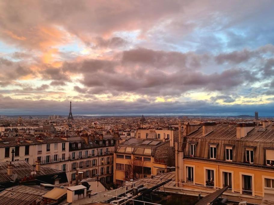 a view of a city under a cloudy sky at Luxury flat with amazing view on Eiffel Tower in Paris