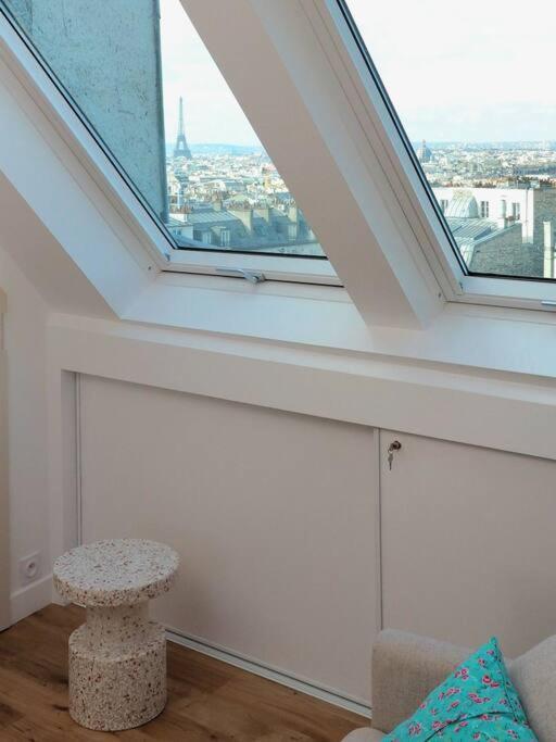 a living room with a large window and a stool at Luxury flat with amazing view on Eiffel Tower in Paris