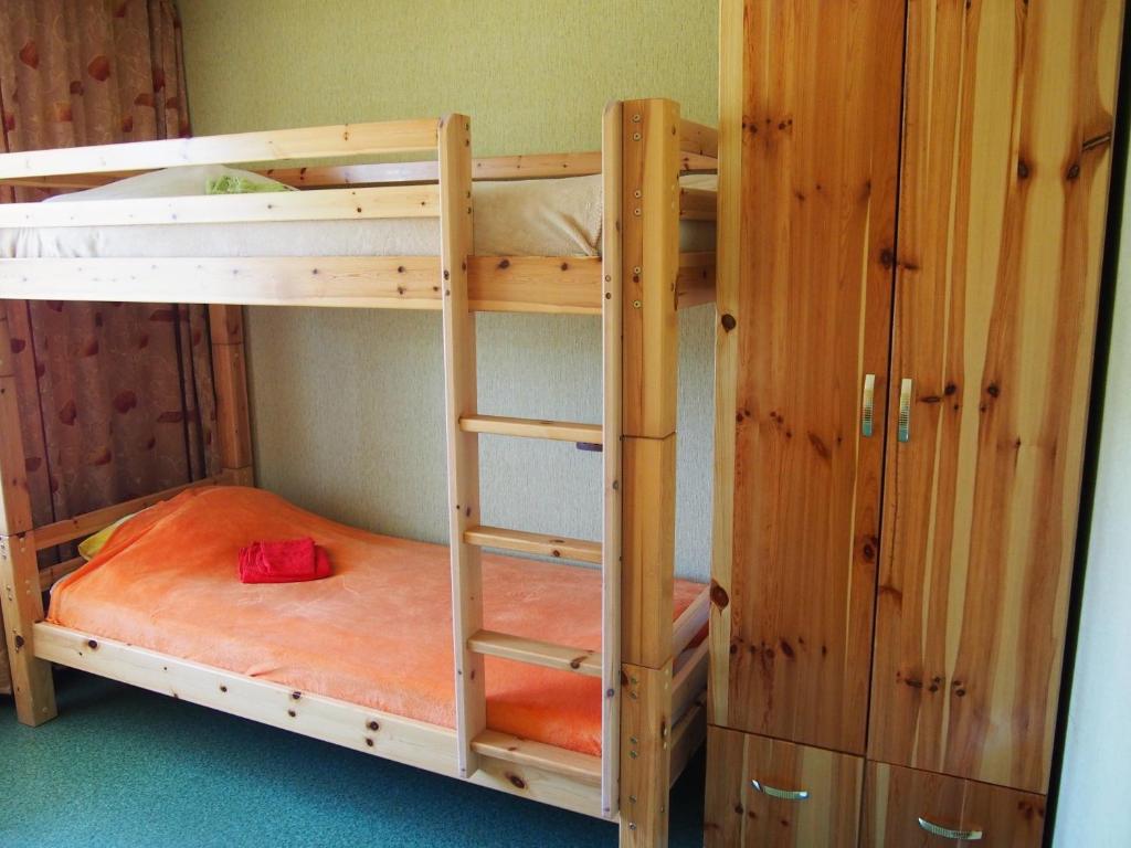 a bunk bed room with two bunk beds and a cabinet at Dzīvokļi Dunikas ielā 1 in Liepāja