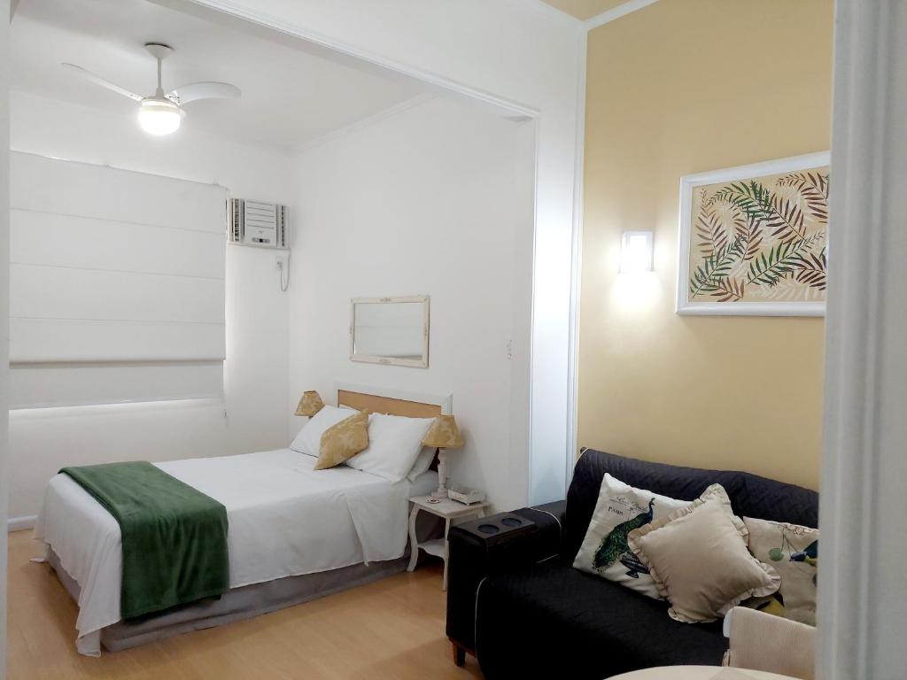 a bedroom with a bed and a couch at Bem Localizado Botafogo in Rio de Janeiro